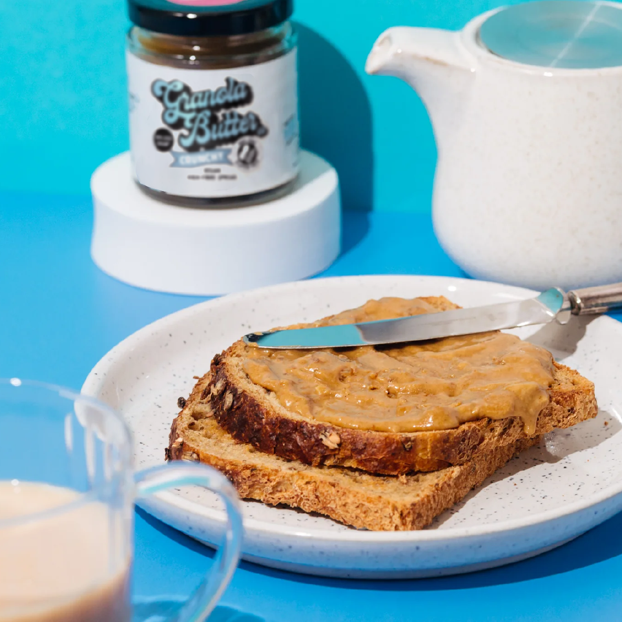 Two slices of brown toast with crunchy granola butter spread evenly across both slices, the new breakfast spread on the block, resembles peanut butter on toast.